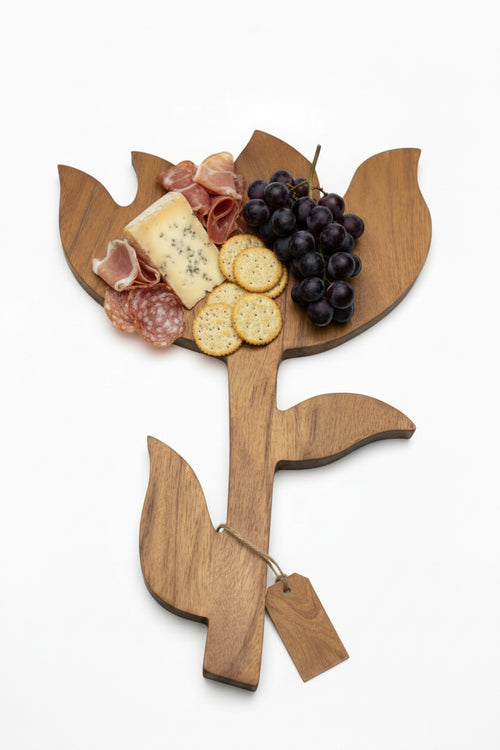 Wooden leaf-shaped cutting board with a ling stem and wooden leaf on a white background
