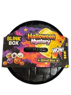 A circular black plastic Halloween mystery blind box with a colorful printed cardboard insert. The insert features festive graphics including jack-o'-lanterns, a full moon, and the text 'Halloween Mystery', 'BLINK BOX', and 'WOW!'.