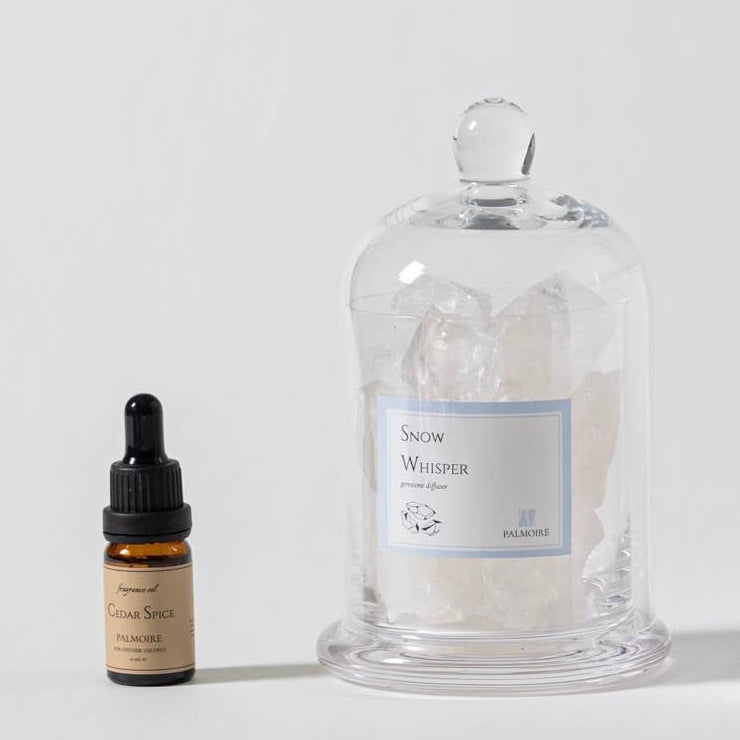 Product packaging with a bottle, jar, and box on a white background. Quartz gemstone cloche diffuser