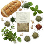 FULL MOOD Benamati Bread Oil gourmet seasoning mix surrounded by fresh herbs, garlic cloves, and sliced crusty bread.