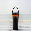FULL MOOD black aquaculture mesh wine caddy with orange accent strap on a white wooden table at the beach