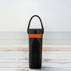 FULL MOOD black aquaculture mesh wine caddy with orange accent strap on a white wooden table at the beach