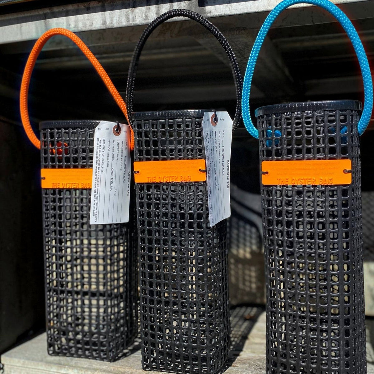 FULL MOOD black oyster mesh wine caddy with orange accents and harvest tag for carrying wine bottles