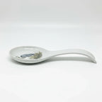 FULL MOOD ceramic spoon rest featuring a blue heron illustration on a white glazed surface for kitchen organization