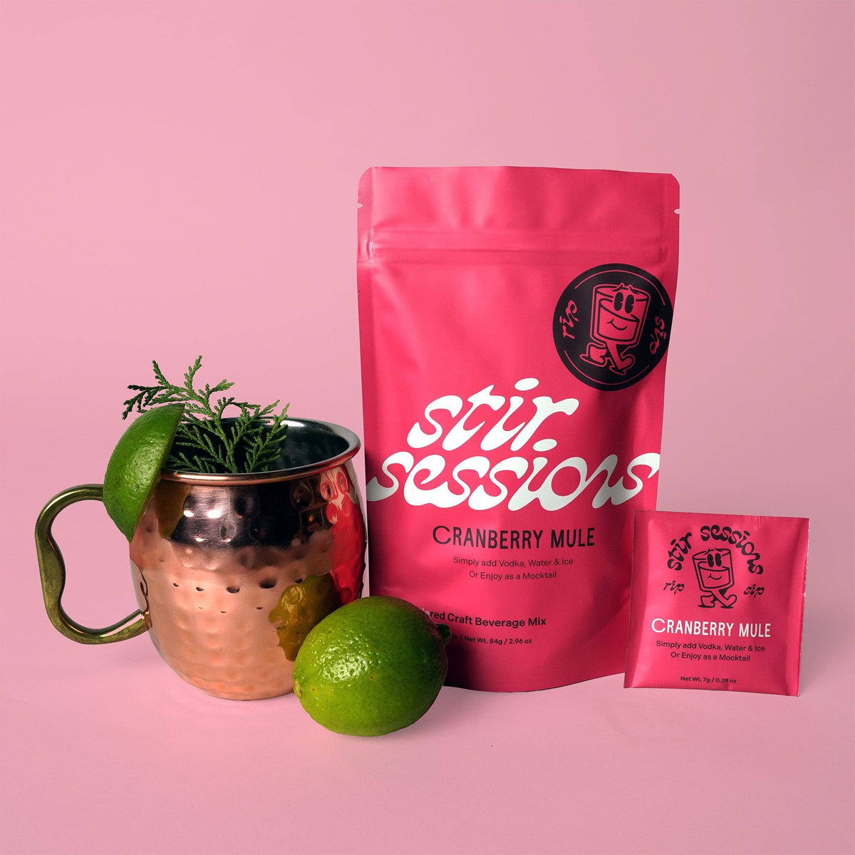 FULL MOOD Stir Sessions Cranberry Mule cocktail mix pouch and packet with a copper mug, lime, and greenery.