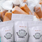 FULL MOOD Dr. Monkey's Monkey Mix caramel bags with individually wrapped golden caramel candies in the background