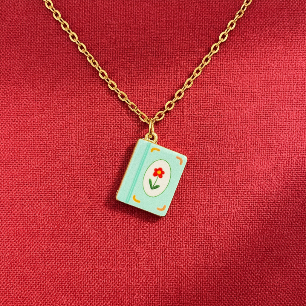 FULL MOOD 18K gold-plated stainless steel necklace featuring a light blue enamel book pendant with a red flower.