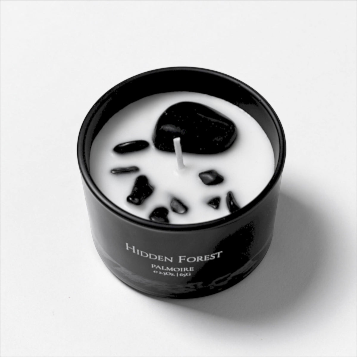 FULL MOOD Hidden Forest soy wax candle in a black glass jar with embedded polished black gemstones
