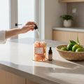 FULL MOOD Himalayan Salt gemstone diffuser with citrus fragrance oil being applied by hand on a kitchen counter