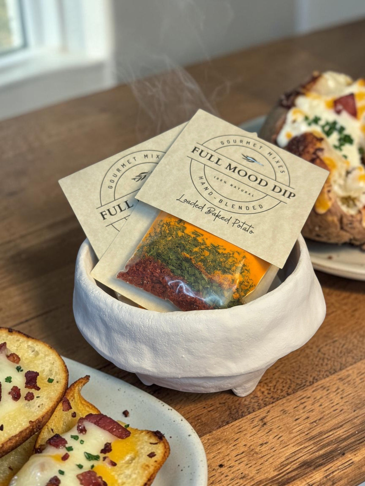 FULL MOOD Loaded Baked Potato dip mix packet featuring cheddar, bacon, and chives in a rustic white ceramic bowl.
