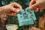 FULL MOOD Stir Sessions Classic Margarita cocktail mix packet being torn open outdoors with a prepared drink nearby.
