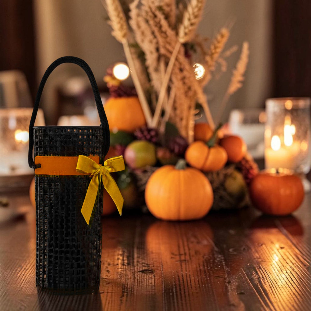 FULL MOOD Oyster Black wine caddy made from durable aquaculture material with a decorative yellow bow on a table.