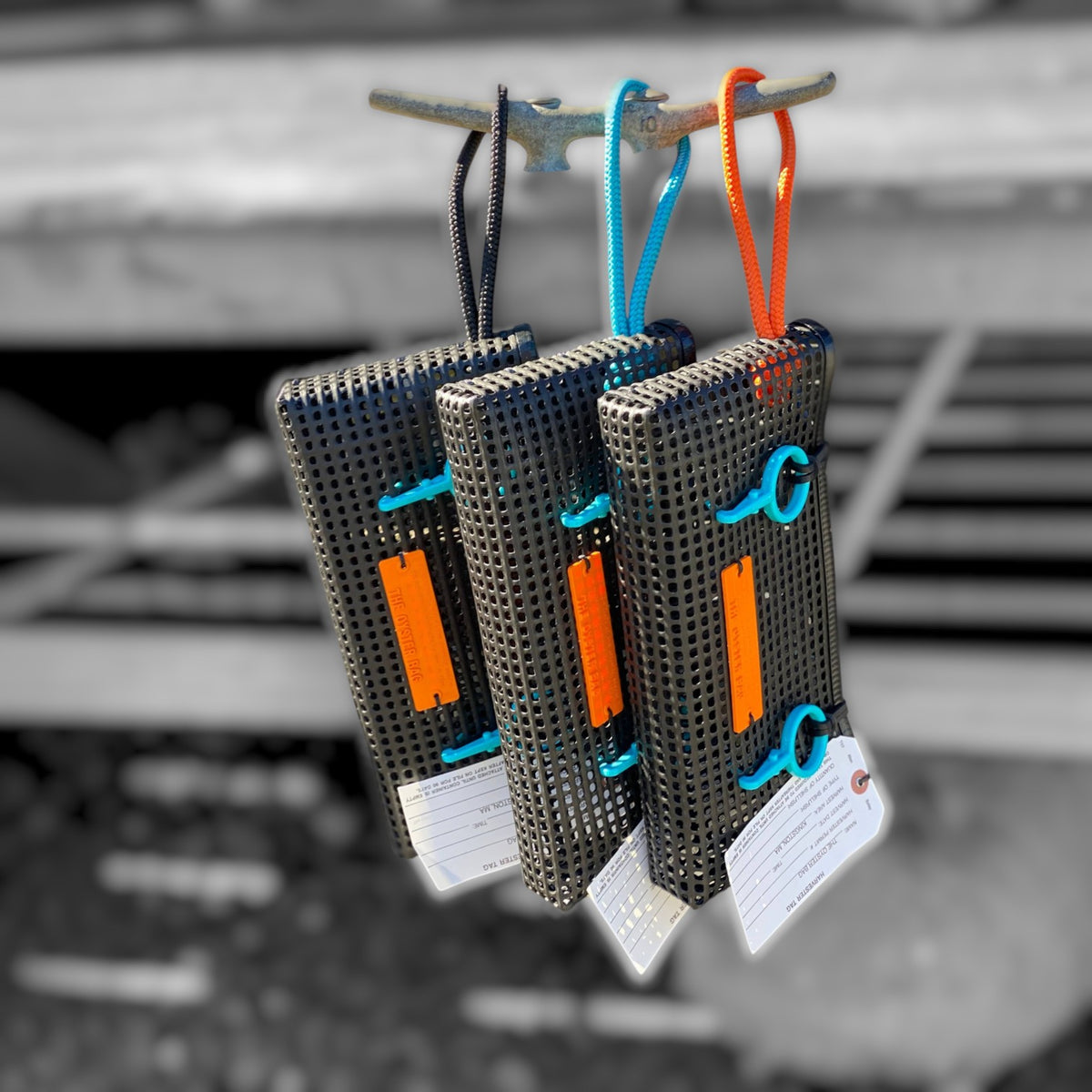 FULL MOOD The Clutch oyster bags in black mesh with vibrant orange and blue rope handles and matching tags.