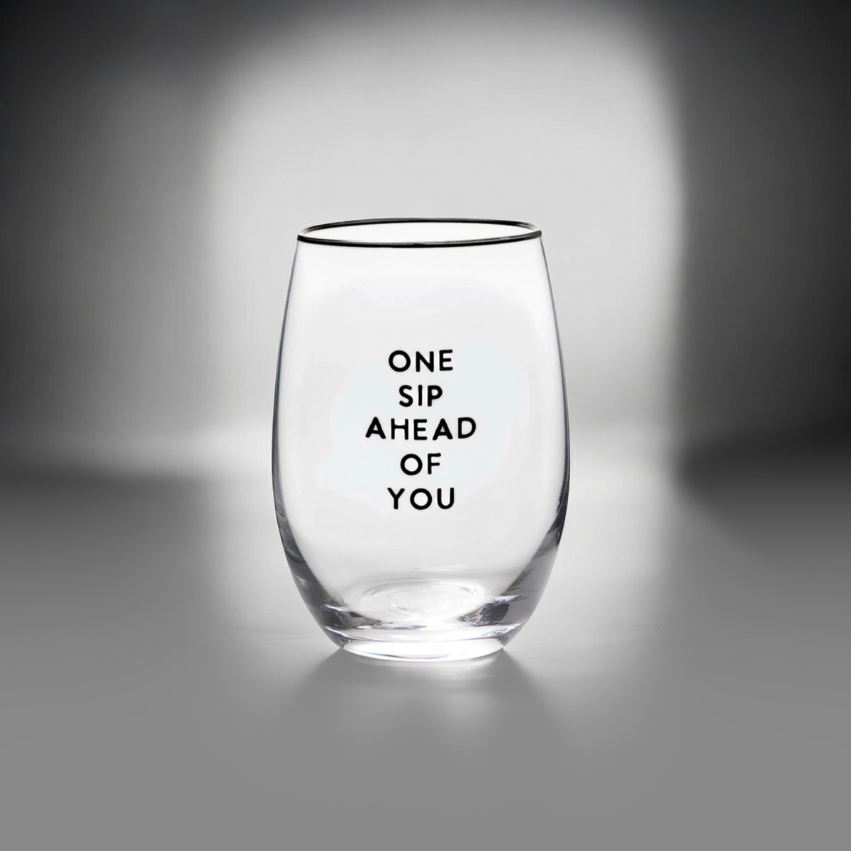 FULL MOOD stemless wine glass featuring the black text One Sip Ahead of You on clear glass