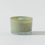 FULL MOOD Tea House soy wax candle in a sage green glass jar topped with a raw green gemstone on a white background.