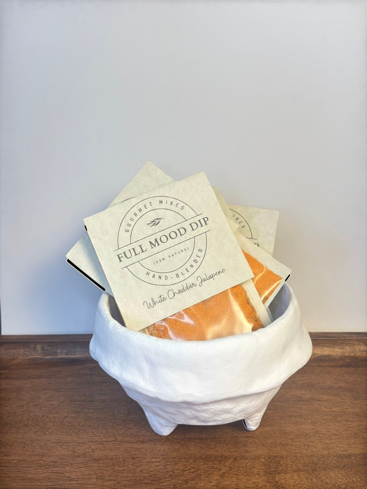FULL MOOD White Cheddar Jalapeno dip mix packets in a white ceramic bowl on a wooden surface.