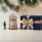 FULL MOOD Himalayan Salt gemstone diffuser with fragrance oil and a blue gift box under pine branches with fairy lights