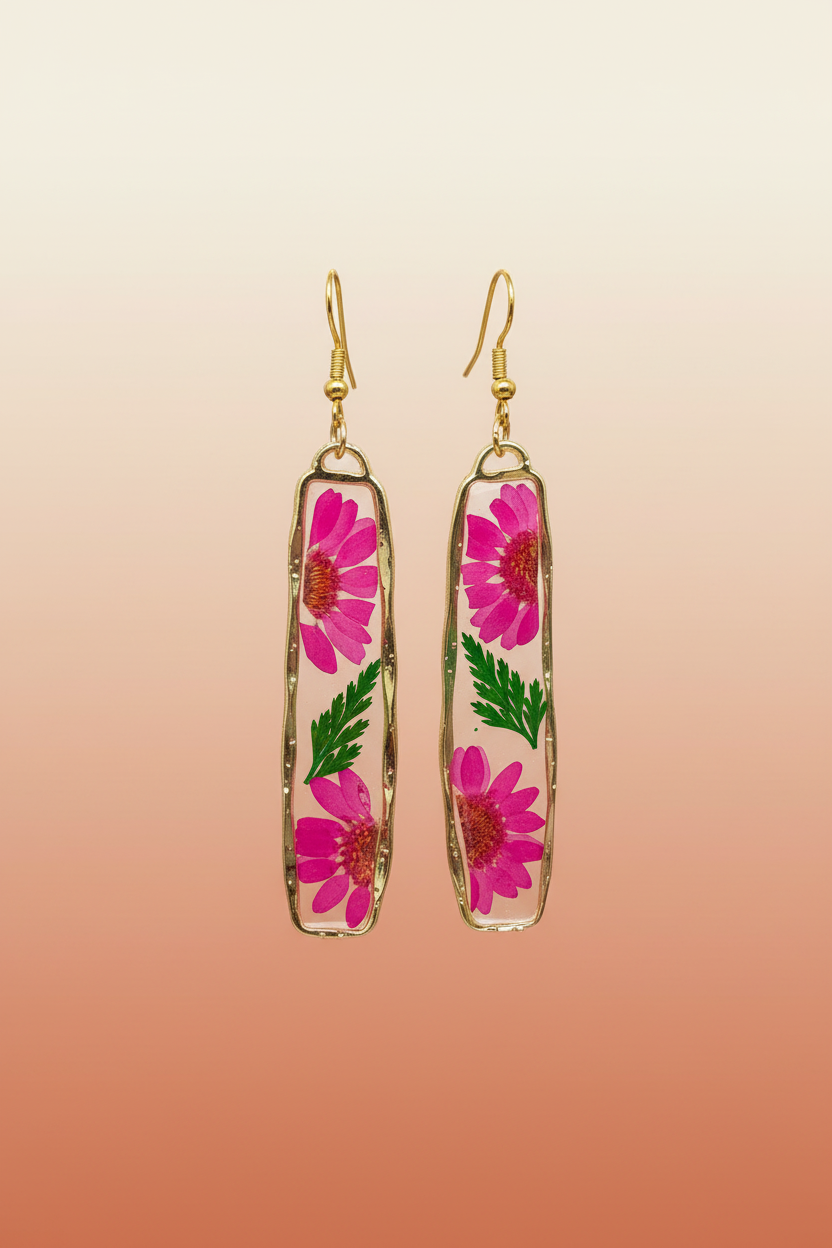 Pressed dried flower dangle earrings hanging against terracotta background
