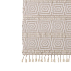 Beige patterned rug with tassels on a white background